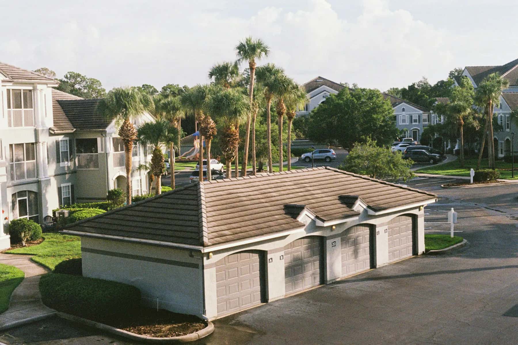 Apartment community with detached garages, palm trees and landscaped parking areas