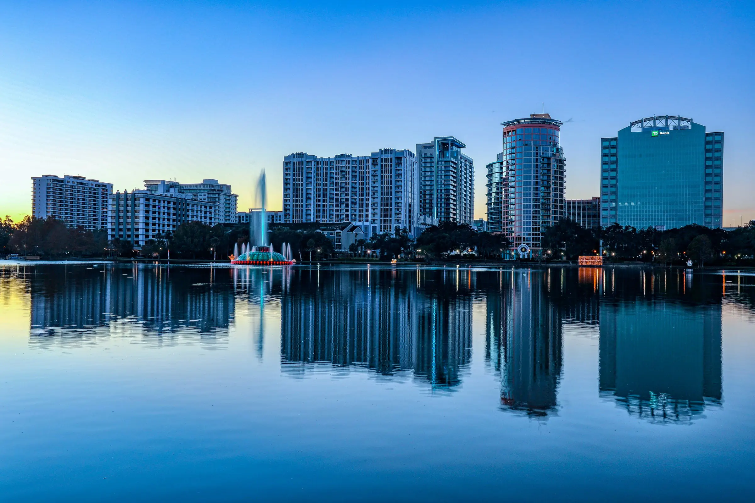 Downtown Orlando skyline and the Lake Eola fountain reflected in the lake at sunrise